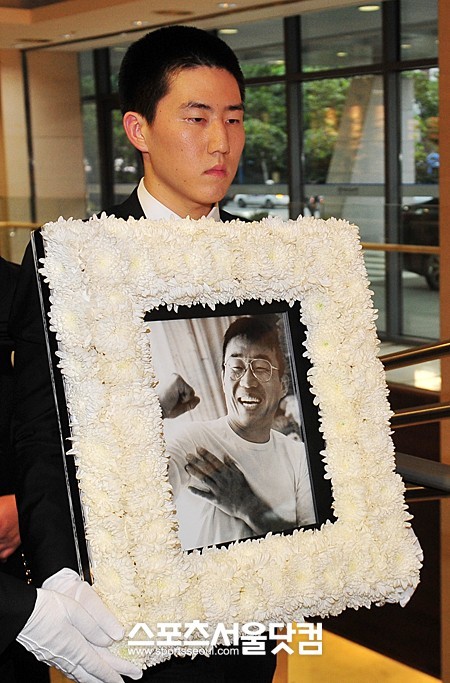 ▲ 고 최동원 감독관의 영정을 들고 장례식장을 나서고 있는 아들 최기호씨<사진 - 문병희 기자>
