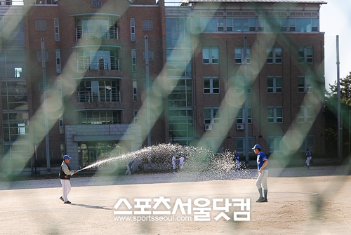 ▲ 60대의 이 감독은 여전히 20대 초반 야구부원들과 야구를 즐긴다. 선수들의 더 나은훈련 환경을 위해 그라운드에 물을 뿌리고 있는 이광환 감독(왼쪽).