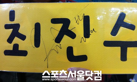 ▲경기 후 김미선씨는 자신이 직접 만든 플래카드 위에 받은 최진수의 사인을자랑했다.