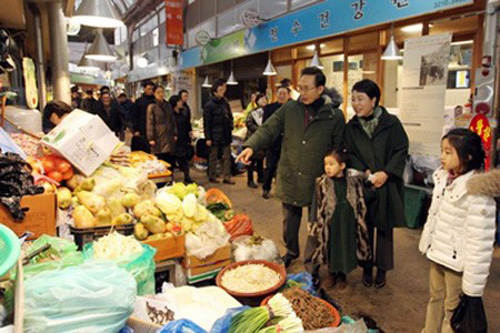 ▲ 이명박 대통령 내외(가운데)가 지난 21일 두 외손녀와 함께 전통시장을 찾았다가 손녀가 입은 고가의 명품 패딩 점퍼(오른쪽 흰색) 탓에 비난을 받았다./청와대 제공