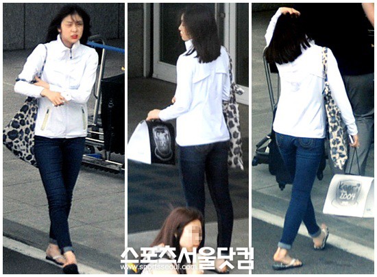 김연아가 청바지에 슬리퍼를 신고 편안한 복장으로 출국장으로 향하고 있다.