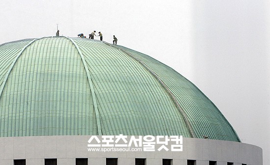 서울지역에 소나기가 예보가 내린 4일 오전 관계자들이 서울 여의도 국회의사당의 돔을 수리하고 있다./임영무 기자