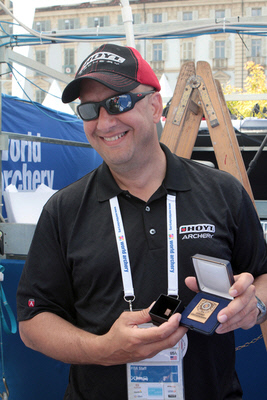 전문지식과 재치있는 말솜씨로 양궁 관중들의 인기를 독차지하고 있는 전문 아나운서 테크미초프. 사진은 지난해 국제양궁연맹에서 공로상을 받은 모습.   출처 | 국제양궁연맹홈페이지