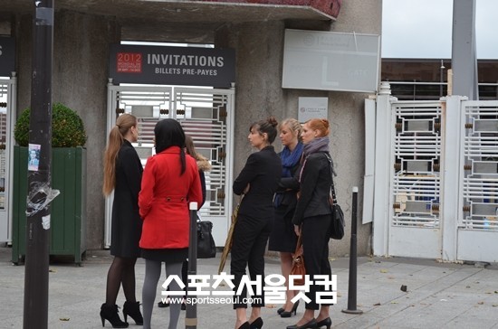 모델로 보이는 미녀들이 파리모터쇼 출입구 인근에 모여 있다.