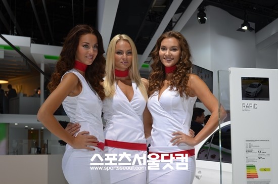 2012 파리모터쇼에서 모델들이 자동차 옆에서 포즈를 취하고 있다.