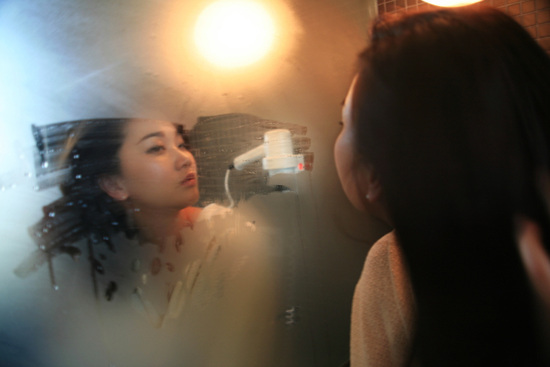 장윤주가 거울을 보며 자연스러운 포즈를 취하고 있다.