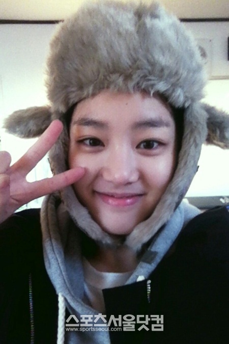 이유비가 화장을 하지 않고 귀여운 털모자를 쓴채 밝은 표정을 짓고 있다.