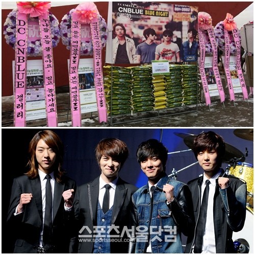 지난 15일 네번째 콘서트 블루 나이트 개최를 축하하며 팬들이 보내온 쌀 화환 1.25톤을 기부하기로 한 록밴드 씨엔블루가 파이팅을 하고 있다./ 더팩트DB, 나눔스토어 제공