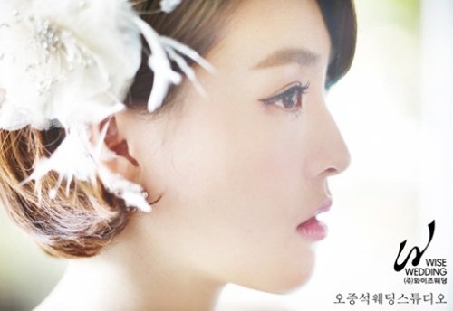 박지현 아나운서가 머리에 꽃장식을 한 채 몽환적 표정의 옆모습을 선보이고 있다. / 오중석웨딩스튜디오 제공.