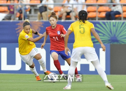 상투머리를 한 전은하(가운데)가 지난해 8월 26일 U-20 여자월드컵 조별 리그 브라질전에서 수비수들 사이로 드리블하고 있다. 제공|대한축구협회