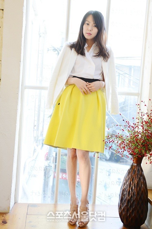 김민희가 노란색 치마를 입고 늘씬한 각선미를 뽐내고 있다.