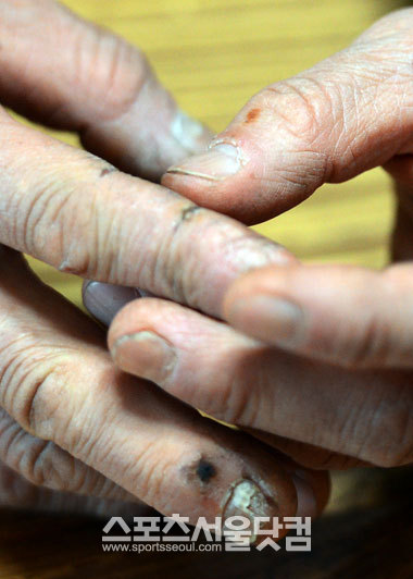 강 전 대표의 험한 손이 그간의 고된 생활을 보여주고 있다.