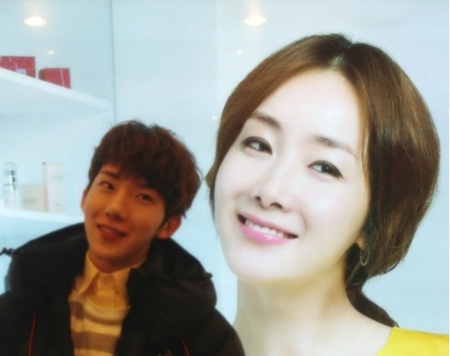 조권(왼쪽)이 최지우의 얼굴이 담긴 간판 앞에 서서 표정을 따라하고 있다. / 조권 트위터