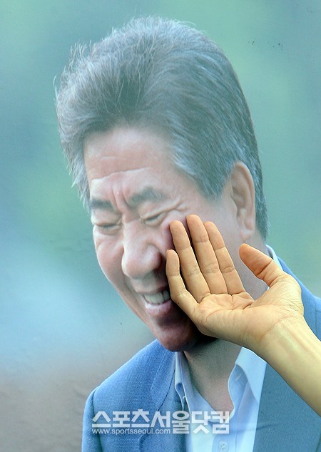 노무현 전 대통령 서거 4주기를 맞은 19일 오후 서울시청앞 서울광장에서 노무현 전 대통령 추모문화제가 열리고 있는 가운데 한 시민이 노 전 대통령의 생전의 사진을 쓰다듬고 있다./임영무 기자