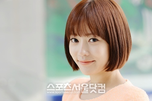 윤아정이 온화한 표정으로 살짝 미소 지으며 시선을 사로잡고 있다.