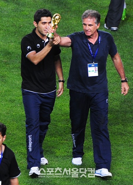 월드컵 모형을 들고 최강희 감독을 향해 도발하는 케이로스 감독.