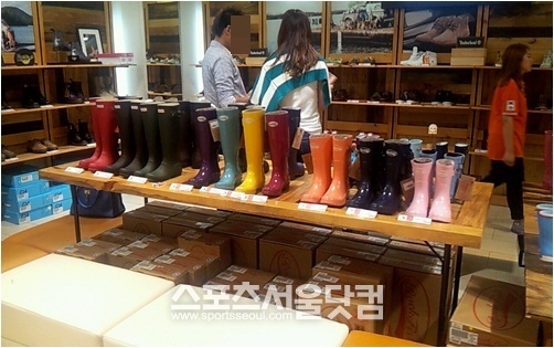 서울시 명동에 있는 한 편집 매장에서 커플이 레인부츠를 신중하게 고르고 있다.