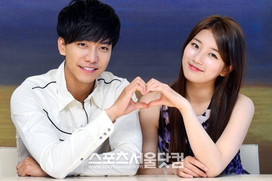 수지(오른쪽)가 MBC 월화드라마 구가의 서에서 함께 나온 이승기와 손으로 하트를 그리고 있다.
