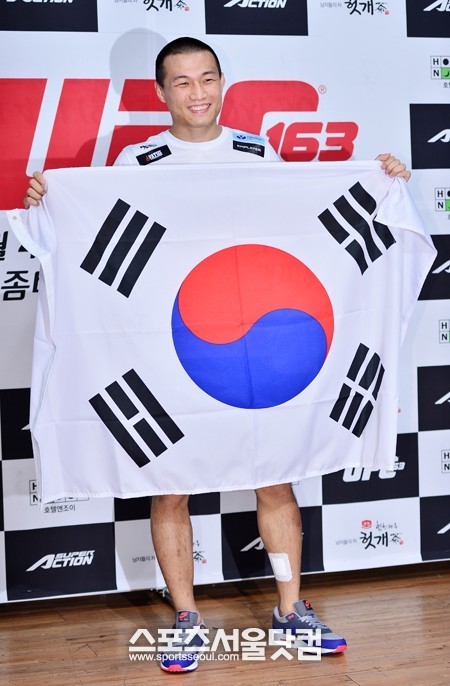 한국 선수로는 처음으로 UFC 챔피언에 도전하는 정찬성이 태극기를 올바르게 들고 활짝 웃고 있다.  / 배정한 기자