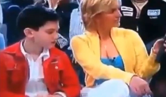 어린 남자 아이가 인터뷰 중인 여자 아나운서의 가슴을 훔쳐보고 있다./유튜브 캡처