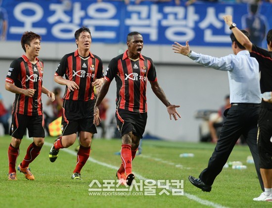 수원과 경기에서 전반 29분 헤딩 선제골을 넣은 뒤 최용수 감독에게 달려가는 서울 수비수 아디(가운데).