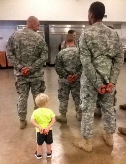 군기 잡힌 아기 게시물 속 노란색 상의의 아기가 군인들과 함께 열중쉬어 자세를 하고 있다. / 온라인커뮤니티