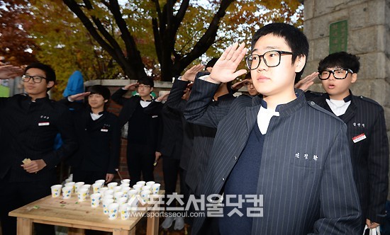 2014학년도 대학수학능력시험이 실시된 7일 오전 수원고등학교 2학년 학생들이 경기 수원 수성고등학교 앞에서 선배님 고득점을 기원하며 거수경례를 하고 있다./수원=임영무 기자