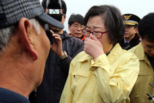 윤진숙 해양수산부 장관이 여수 기름 유출지역 현장을 방문해 피해 주민 앞에서 입을 가리고 있다. / 서울신문 제공