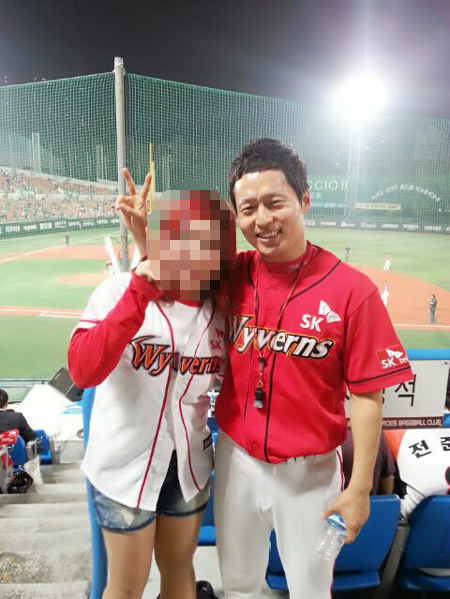 프로야구 SK 와이번스의 응원단장으로 활약해 온 박홍구 씨가 최근 구단으로부터 해임 통보를 받아 이를 둘러싼 의혹이 커지고 있다. 사진은 경기장에서 SK 팬들과 다정한 포즈를 취하고 있는 박 단장. / 박 단장 페이스북