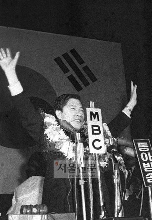 1971년 대선을 앞두고 치러진 신민당 대통령 후보지명전에서 2차까지 가는 투표 끝에 40대기수론을 선창한 김영삼 후보에 역전승을 거두며 후보로 지명된 김대중 후보가 두 팔을 치켜들고 답례하고 있습니다. /서울신문 제공