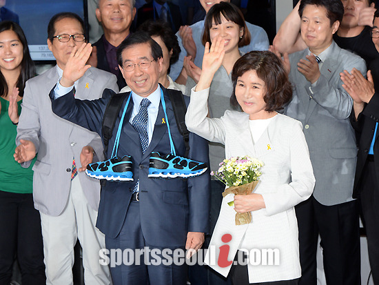 4일 치러진 제6회 전국동시지방선거에서 새정치민주연합 박원순 당선자가 새누리당 정몽준 후보를 누르고 재선에 성공했다. 당선이 확실시되자 박 당선자가 5일 새벽 서울 종로구 종로 5가 캠프에서 아내 강난희 씨와 함께 손을 흔들며 기뻐하고 있다. /종로=이효균 기자