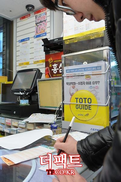 서울시 금천구 가산동의 한 편의점에서 시민이 스포츠토토 용지에 신중하게 표시하고 있다. / 문병희 기자
