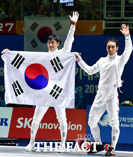 정진선(왼쪽)과 박경두가 20일 2014 인천 아시안게임 남자 에페에서 각각 금메달과 은메달을 확정 지은 뒤 태극기를 들고 기뻐하고 있다. / 배정한 기자