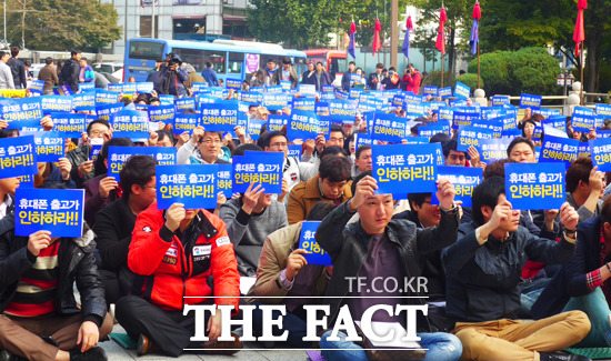 집회에 참가한 이동통신 소상공인들이 휴대폰 줄고가 인하하라는 팻말을 들고 있다.