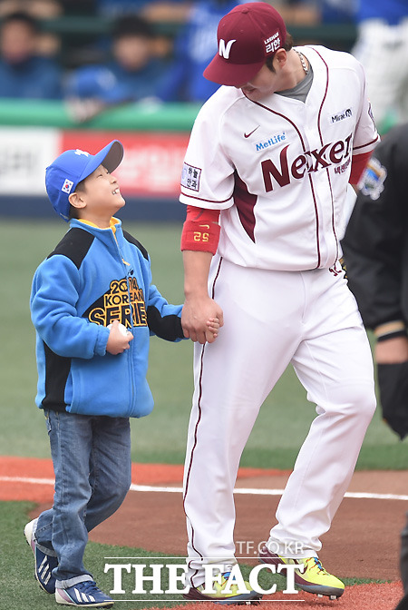 한국시리즈 4차전에서 시구자 이주상 군(왼쪽)과 박병호가 눈을 마주치며 밝게 웃고 있다. / 최용민 기자