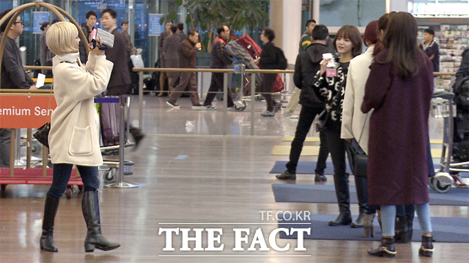 걸그룹 AOA 초아(왼쪽)가 2014 엠넷 아시안 뮤직 어워드 참석을 위해 인천국제공항을 찾은 지난 2일 캠코더로 멤버들을 촬영하고 있다./해당 영상 캡처
