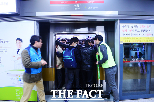 7시 47분 - 탑승을 위해 몸을 억지로 싣는 시민에게 서울시 관계자가 다음 열차를 이용할 것을 권하고 있다.