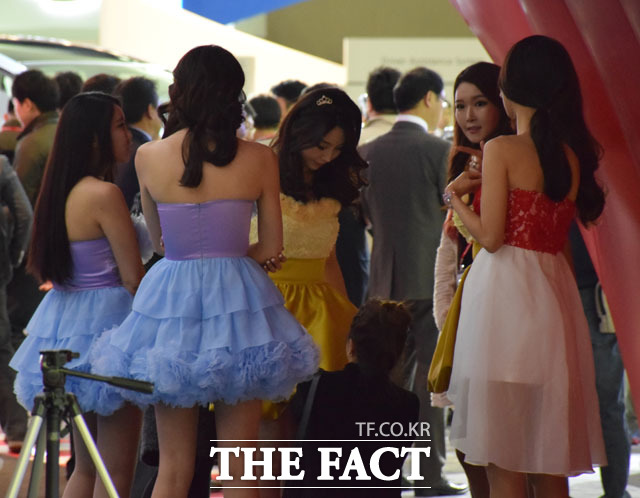 준비하고 있어요 2일 2015 서울모터쇼에서 도요타 부스 레이싱 모델들이 장막 뒤에서 의상을 점검하고 있다. /강희정 인턴기자