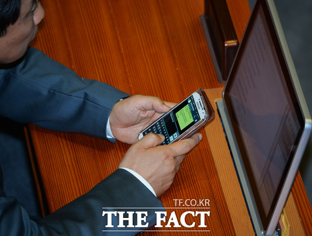 이종걸 원내대표가 최재성 의원이 보낸 문자를 확인한 후 답장을 적고 있다. / 국회=문병희 기자