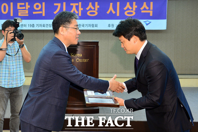 더팩트 이효균(오른쪽) 사진팀장이 박종률 한국기자협회장으로부터 이달의 기자상을 받고 있다./남윤호 기자