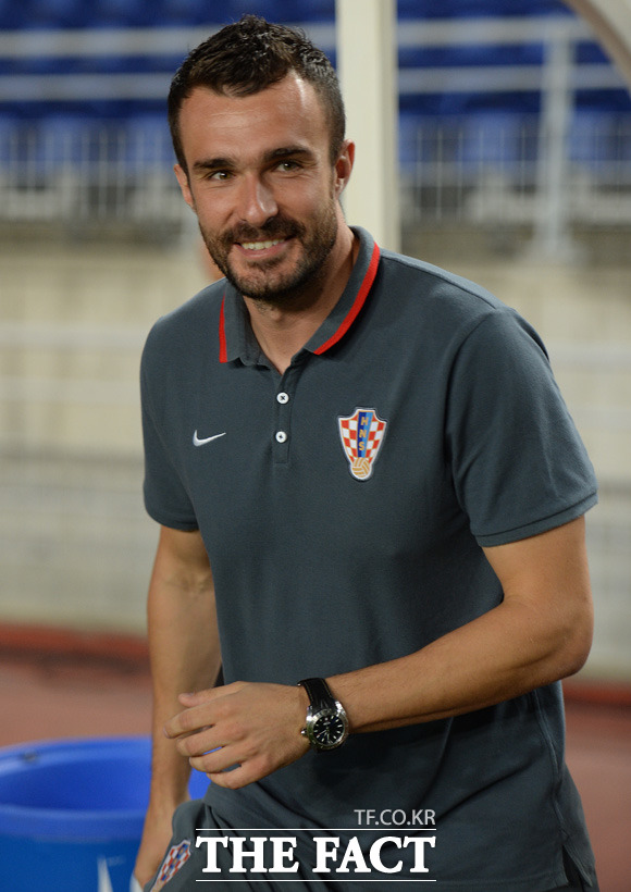 크로아티아 다리오 바시치 감독이 경기 전 미소를 보이며 그라운드에 서 있다.