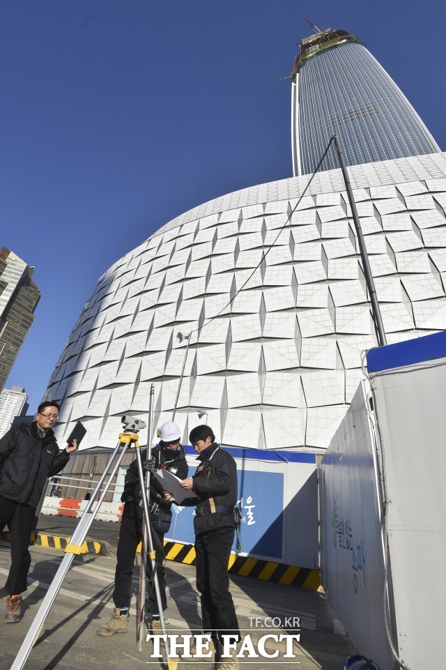 지난 1월 제2롯데월드 롯데월드몰 앞 도로가 침하가 발견됐다고 서울시가 밝힌 가운데 롯데 관계자들이 제2롯데월드 앞 송파대로에서 도로 침하 관련 측량을 하고 있다. /더팩트DB
