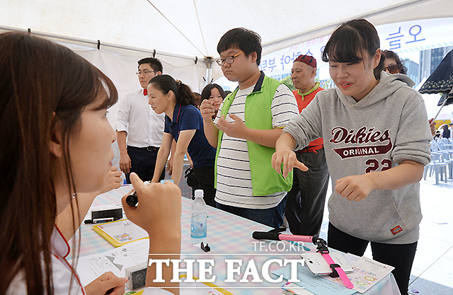 수화로 의사소통 도전 - 19일 오전 서울 광화문 북측광장에서 열린 청각·언어장애인과 일반시민이 함께하는 제10회 서울특별시 수화문화제에서 일반시민들이 전문가로부터 수화 실력을 평가 받고 있다.