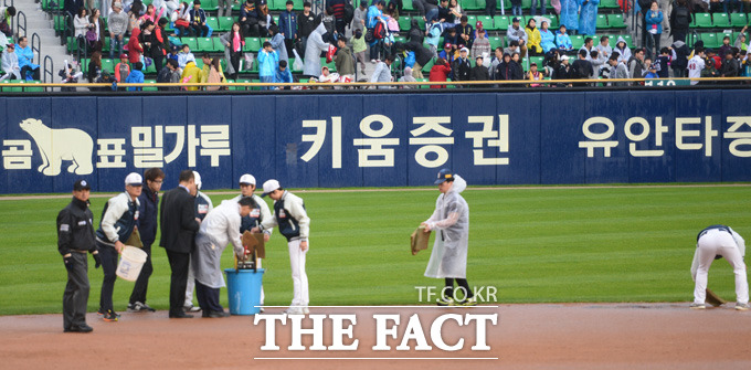 넥센 8회초 갑작스런 소나기가 내리며 경기가 중단되고 있다. 관계자들이 그라운드 물기를 제거하고 있다.