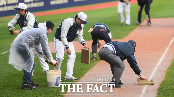 넥센 8회초 갑작스런 소나기가 내리며 경기가 중단되고 있다. 관계자들이 그라운드 물기를 제거하고 있다.