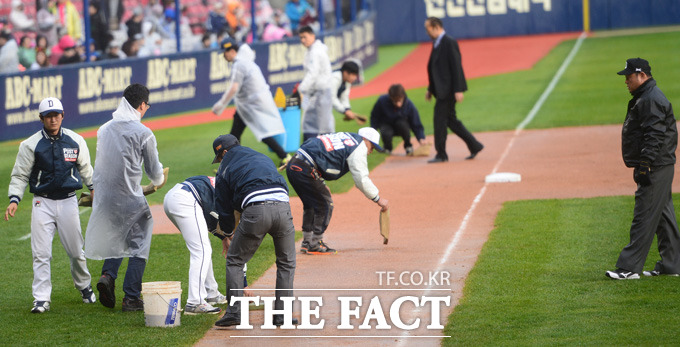 넥센 8회초 갑작스런 소나기가 내리며 경기가 중단되고 있다. 관계자들이 그라운드 물기를 제거하고 있다.