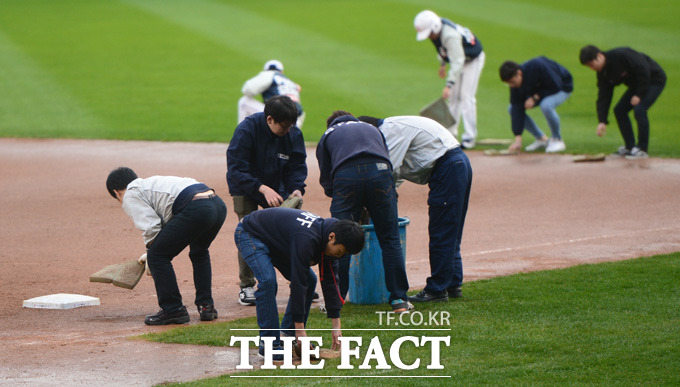 넥센 8회초 갑작스런 소나기가 내리며 경기가 중단되고 있다. 관계자들이 그라운드 물기를 제거하고 있다.