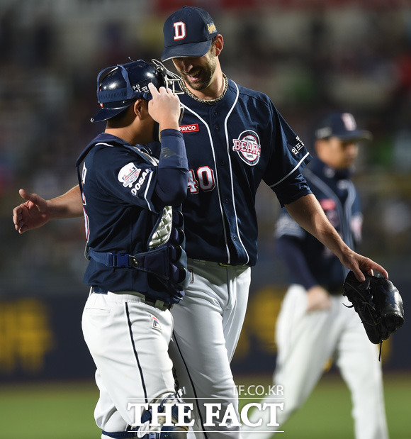 두산 선발 니퍼트가 6회말 삼성 나바로에게 홈런성 타구를 허용했으나 김현수가 잡아내자 활짝 웃으며 포수 양의지와 대화를 나누고 있다.