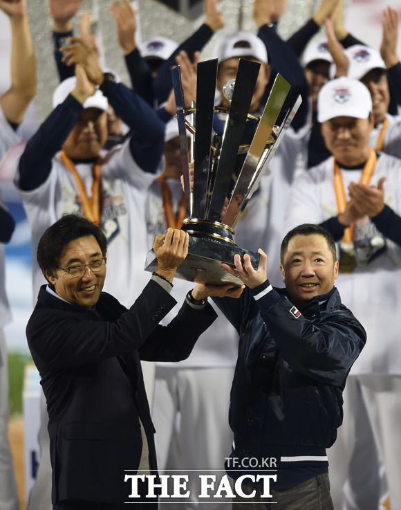 두산 김승영 사장(왼쪽)과 박정원 구단주가 한국시리즈 우승트로피를 번쩍 들고 있다.
