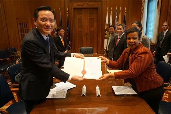 김현웅 법무부장관(왼쪽)이 9일 오전(현지 시각) 워싱턴DC 소재 미국 연방 법무부에서 로레타 린치 미국 법무부장관으로부터 전두환 일가 환수자금 인도증서를 건네받고 있다. /법무부 제공